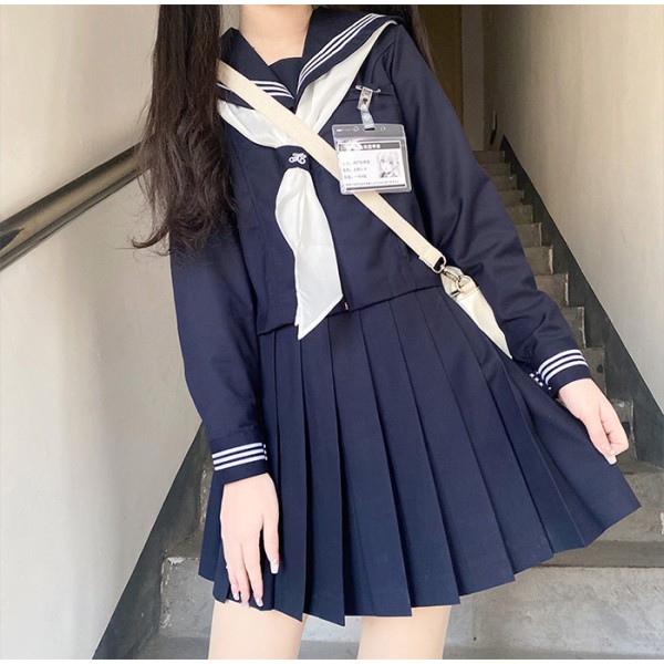 Tummansininen japanilainen koulupuku valkoisella solmiolla